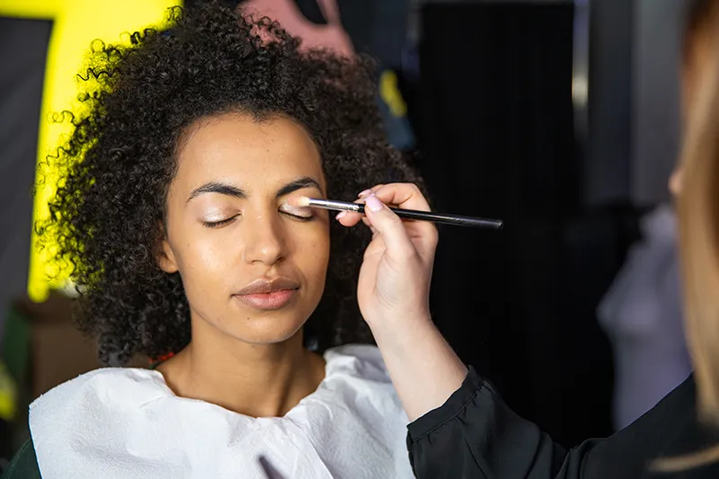 Makeup artist preparing a model for a lookbook shoot